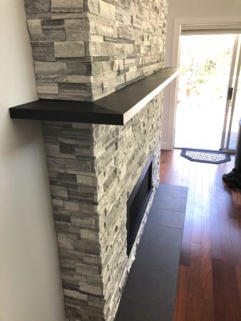 Double Sided Ledgestone Tile Fireplace with Charred Wood Mantle and See-Through Gas Insert with Heat Shift Vent Side 1 Corner Detail - Broadmead