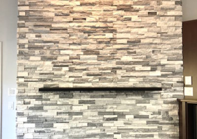 Double Sided Ledgestone Tile Fireplace with Charred Wood Mantle and See-Through Gas Insert with Heat Shift Vent Side 2 Corner Detail - Broadmead