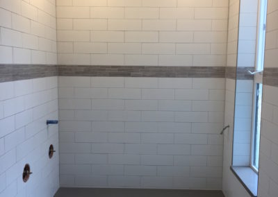 Subway Tile Steam Room Shower with Window, Bench and Stone Accent Band - Fernwood